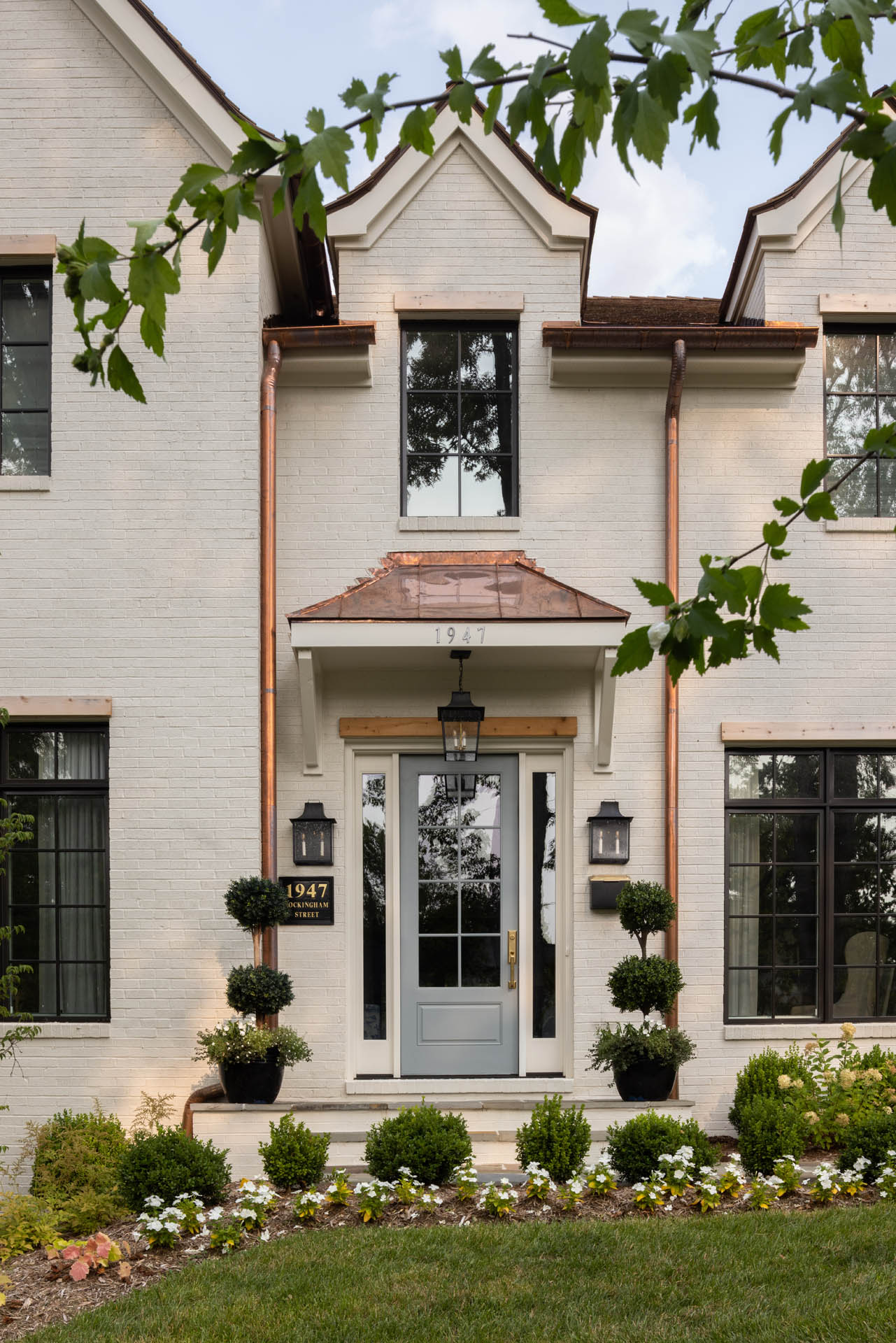 A close-up view of the entrance of a white home with golden pipes