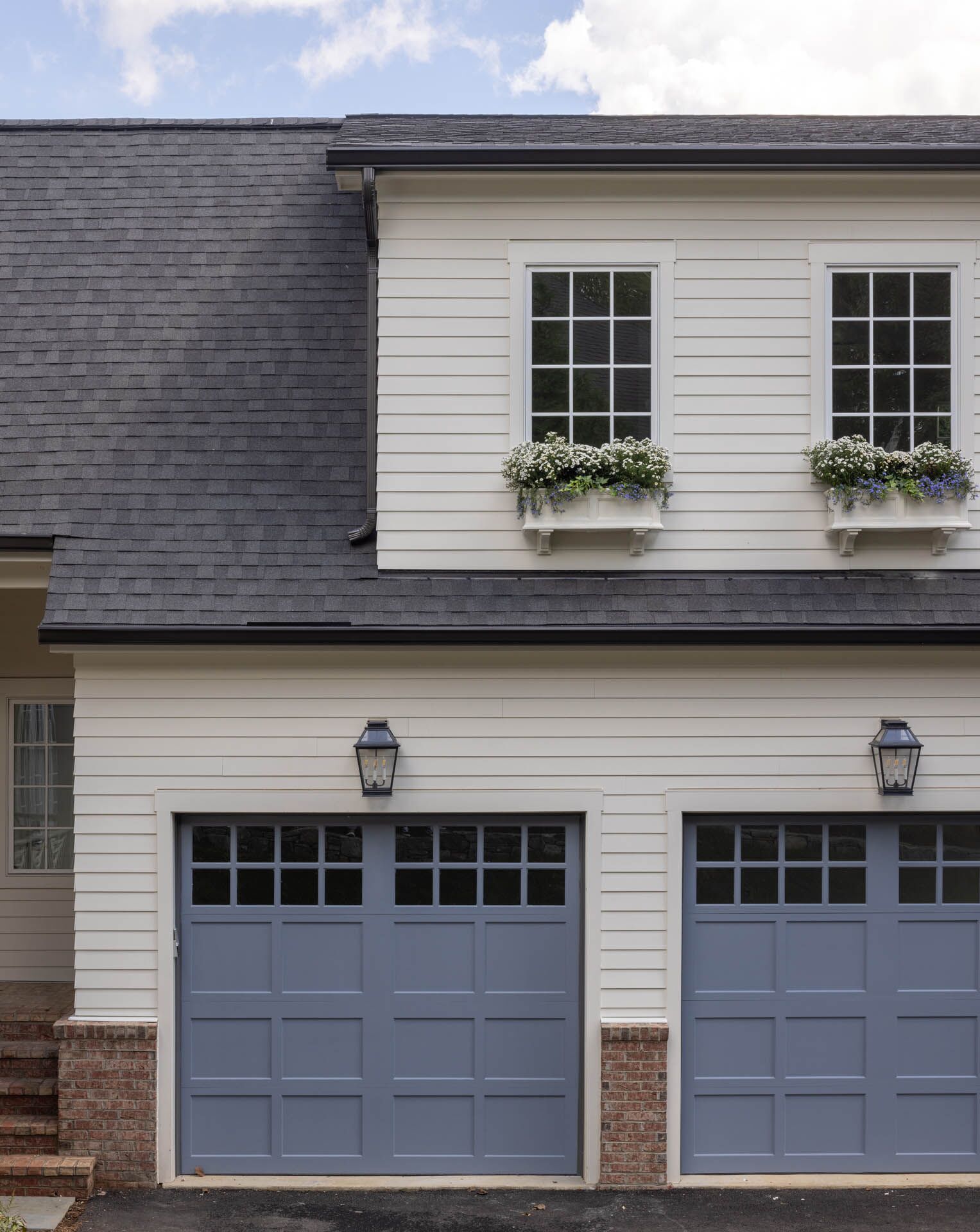 A white house with two dark blue garage doors