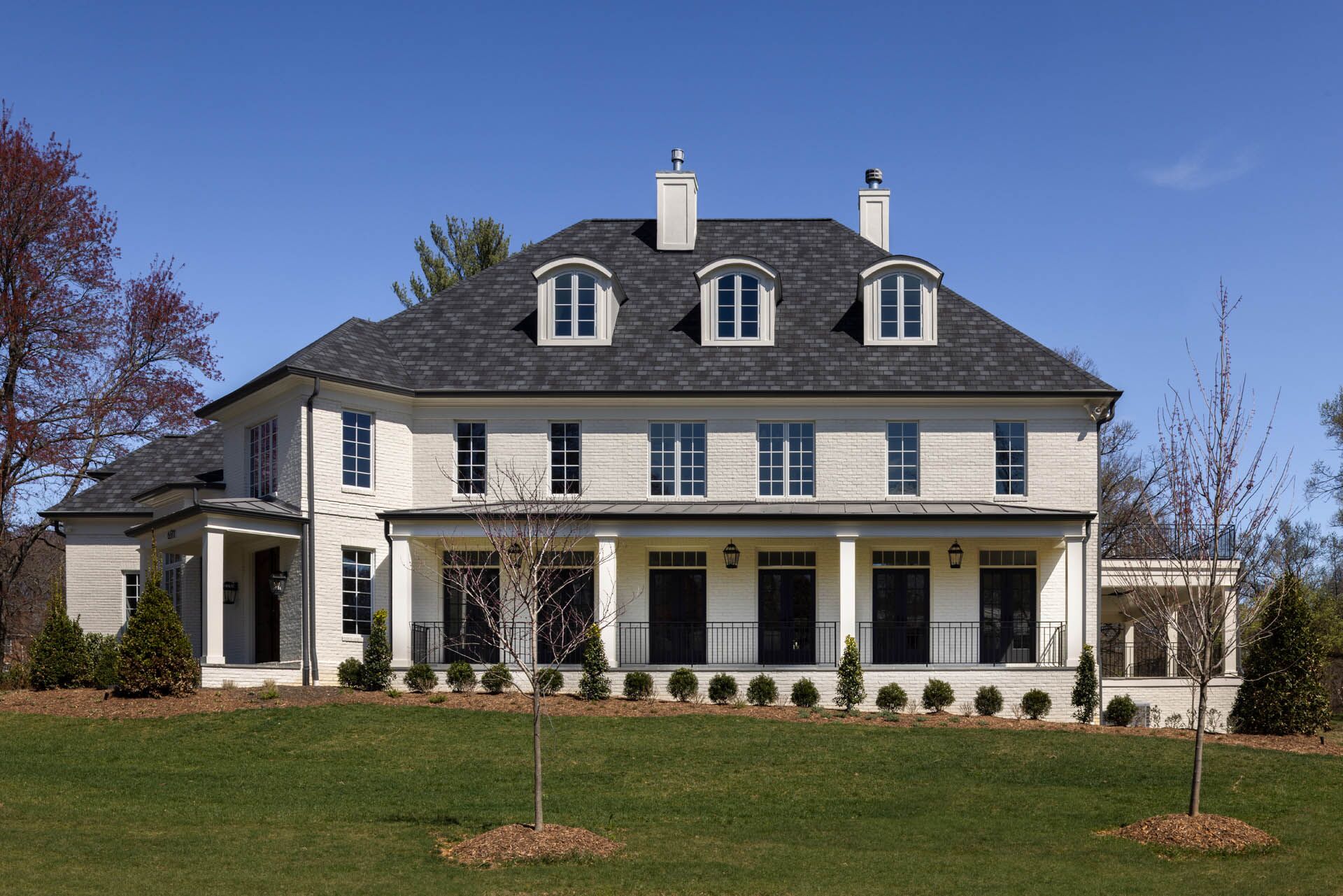 A white house with over a dozen windows facing the street